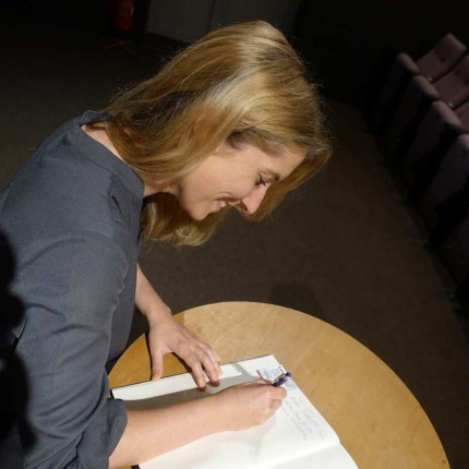 Regisseurin Elisa Scheidt trägt sich in unser Gästebuch ein.